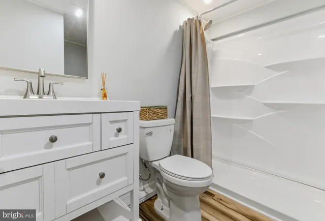 a bathroom with a sink a toilet and shower