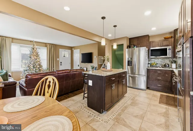 a kitchen with a refrigerator a sink dishwasher with a dining table and chairs