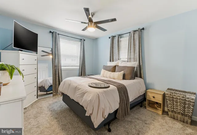 a spacious bedroom with a bed and a flat screen tv