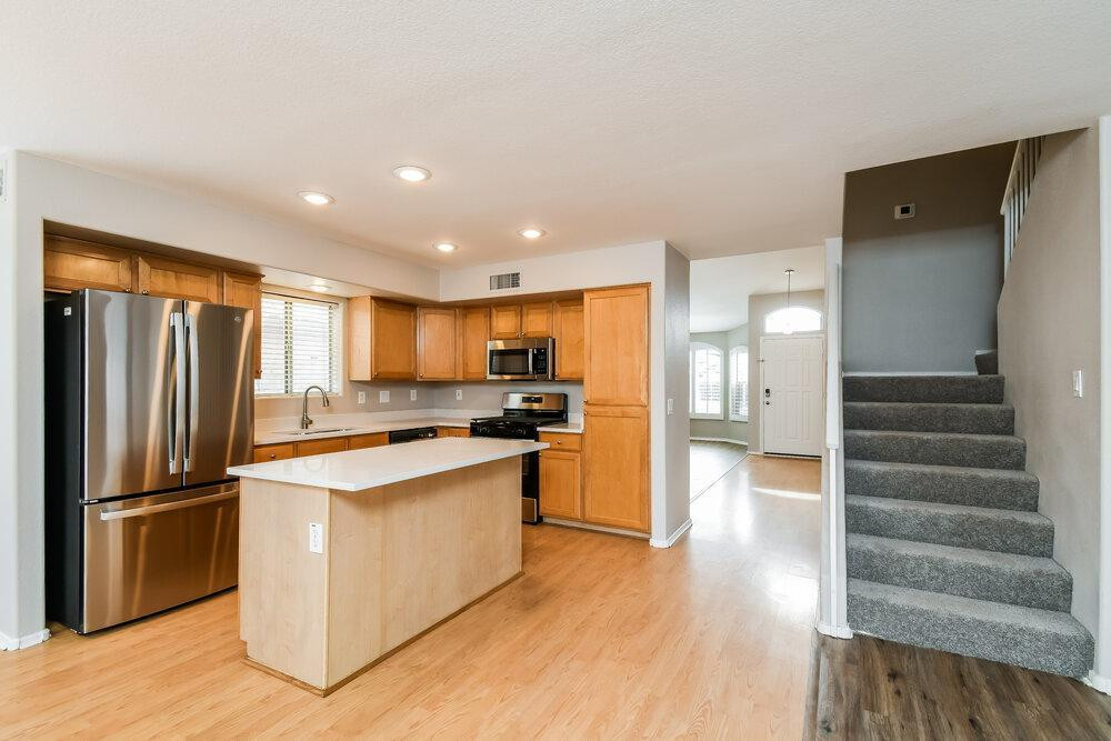 1766 East Tyson Street Gilbert, AZ 85295 - Photo 7 of 17 a kitchen with stainless steel appliances granite countertop a refrigerator a stove and a wooden floors