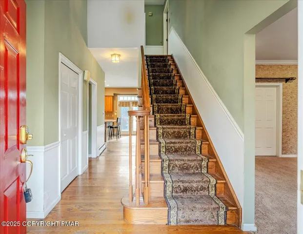 a view of a hallway with wooden floor and staircase