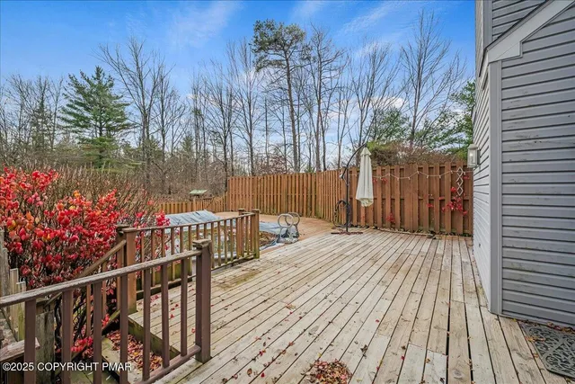 a view of a house with wooden floor fence and a yard