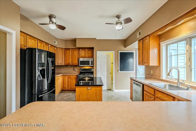 a kitchen with stainless steel appliances granite countertop a sink and a refrigerator