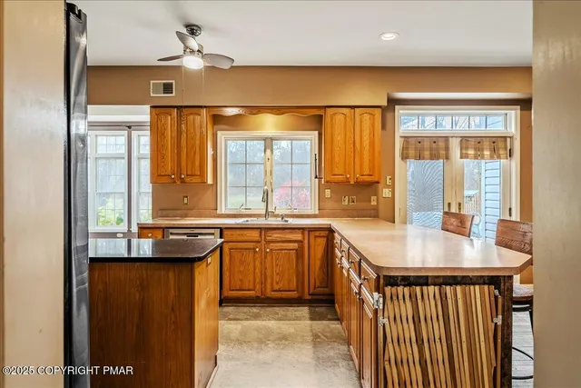 a kitchen with stainless steel appliances granite countertop a sink and a refrigerator