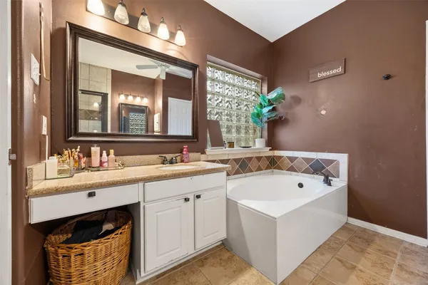 a bathroom with a double vanity sink mirror and bathtub