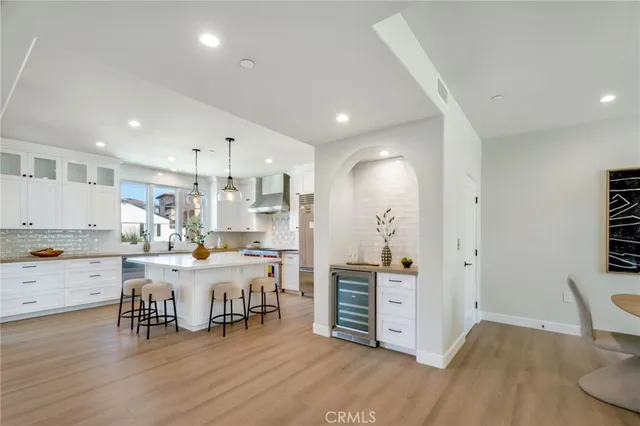 a kitchen with stainless steel appliances wooden floor and large cabinets
