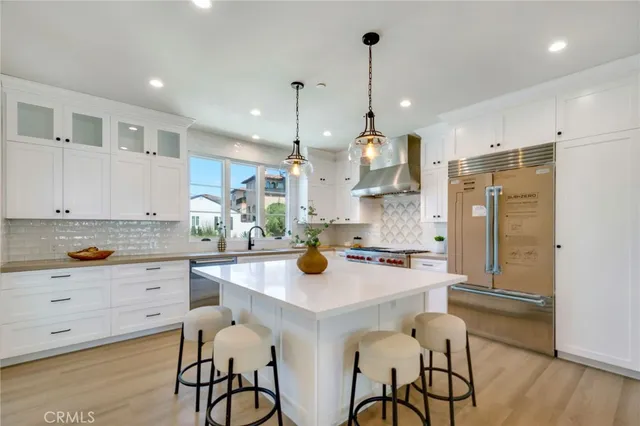a kitchen with a sink a stove a refrigerator and chairs