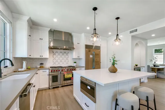 a kitchen with a sink a stove and chairs