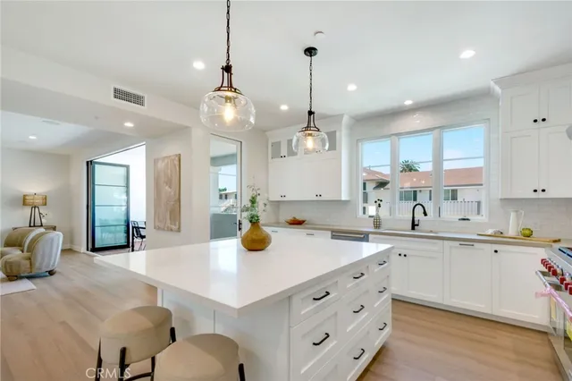 a kitchen with a sink a center island and cabinets