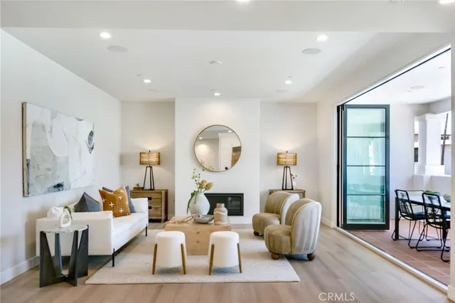 a living room with fireplace furniture and a large window