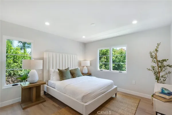 a bedroom with a large bed and a potted plant