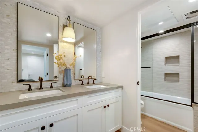 a bathroom with a double vanity sink mirror and shower