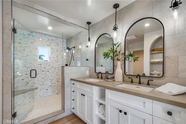 a bathroom with a double vanity sink mirror and shower