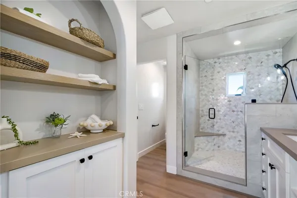 a bathroom with a granite countertop sink a mirror and shower