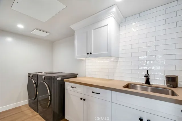 a view of a storage and utility room with sink washer and dryer