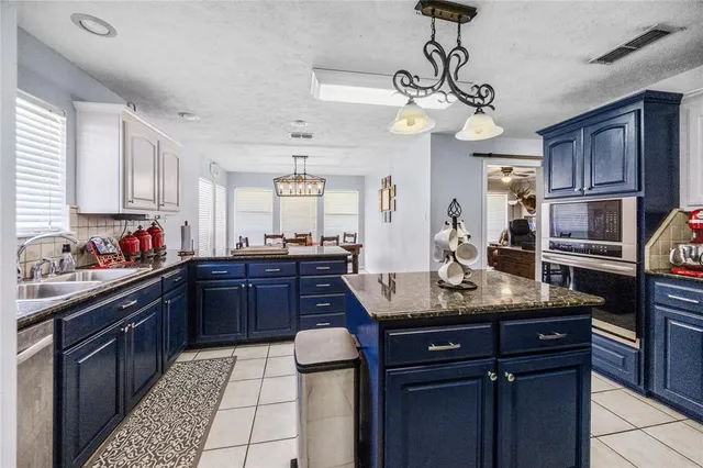 a kitchen with granite countertop stainless steel appliances and wooden cabinets