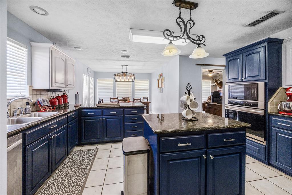 2895 County Road 118 Overton, TX 75684 - Photo 11 of 40 a kitchen with granite countertop stainless steel appliances and wooden cabinets