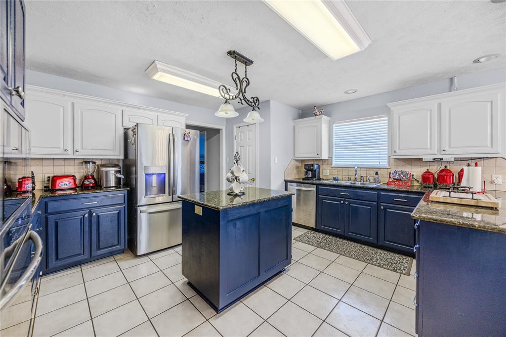 2895 County Road 118 Overton, TX 75684 - Photo 12 of 40 a kitchen with granite countertop a stove sink and cabinets