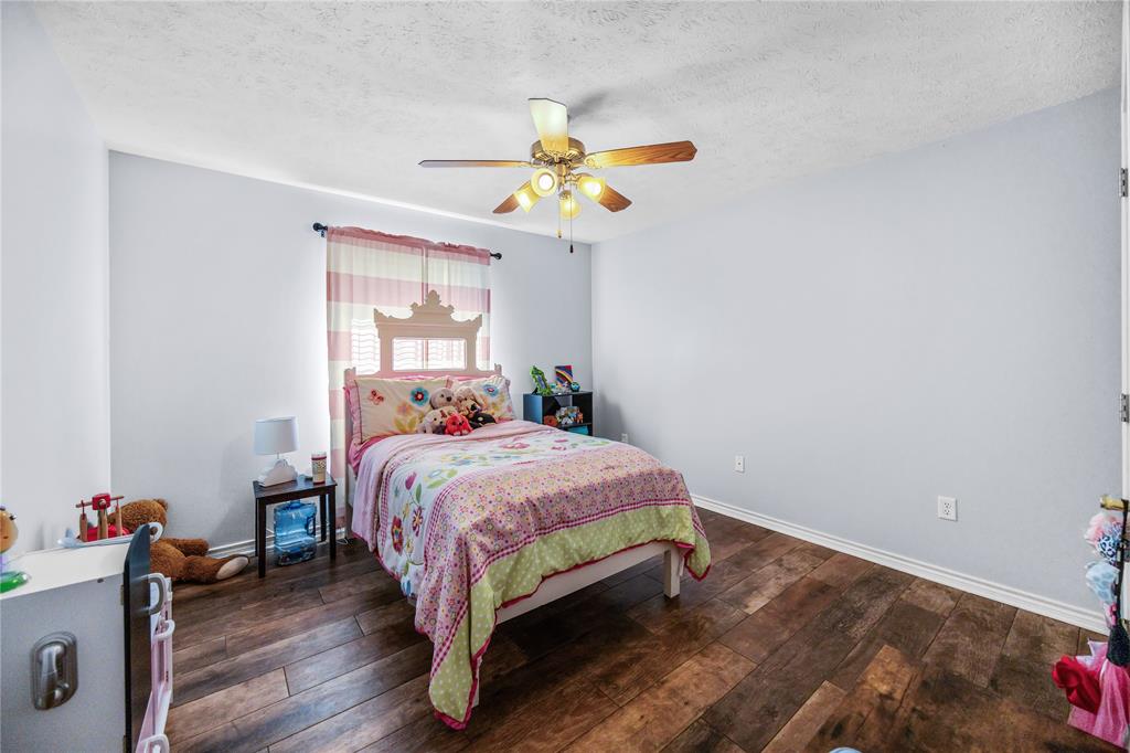 2895 County Road 118 Overton, TX 75684 - Photo 18 of 40 a bedroom with a bed and a chandelier fan