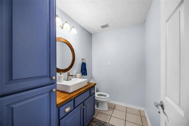 a bathroom with a toilet mirror vanity and a sink
