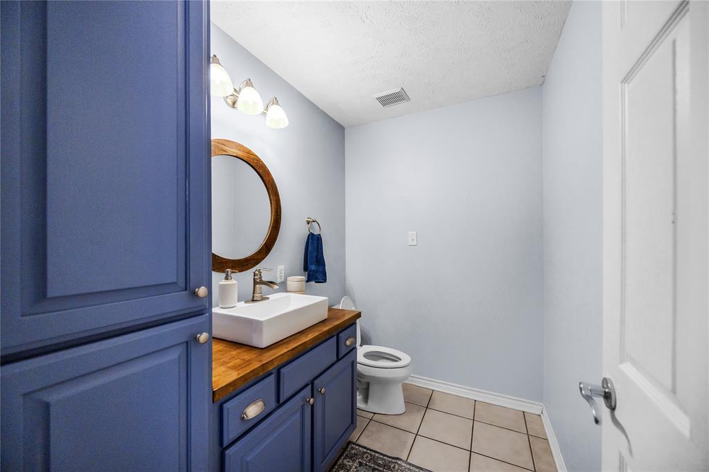 2895 County Road 118 Overton, TX 75684 - Photo 20 of 40 a bathroom with a toilet mirror vanity and a sink