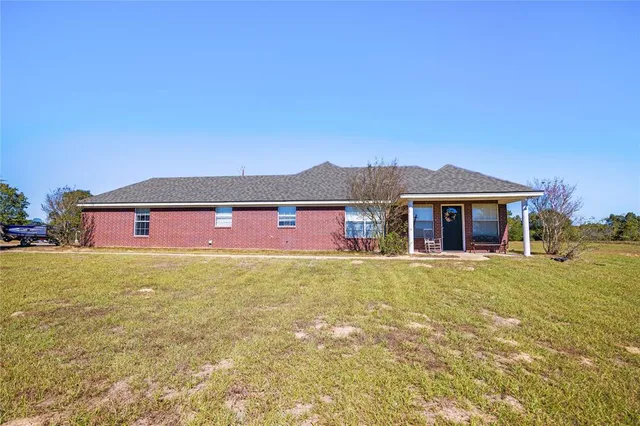 a view of large house with a big yard and large trees