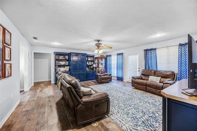 a living room with furniture and a wooden floor