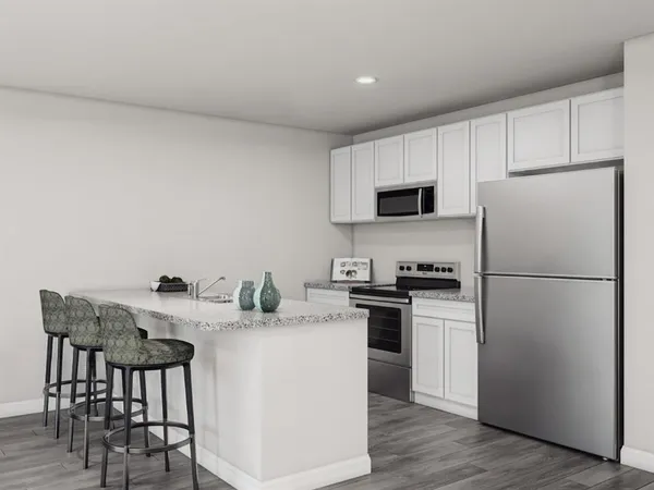 a kitchen with stainless steel appliances a refrigerator stove microwave and white cabinets