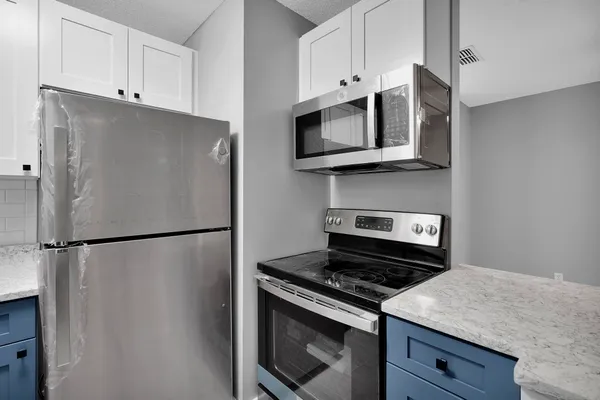 a bathroom with a granite countertop sink vanity mirror and toilet