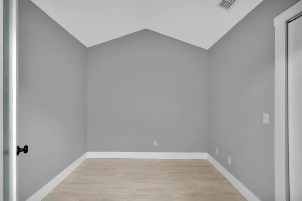 an empty room with windows and closet