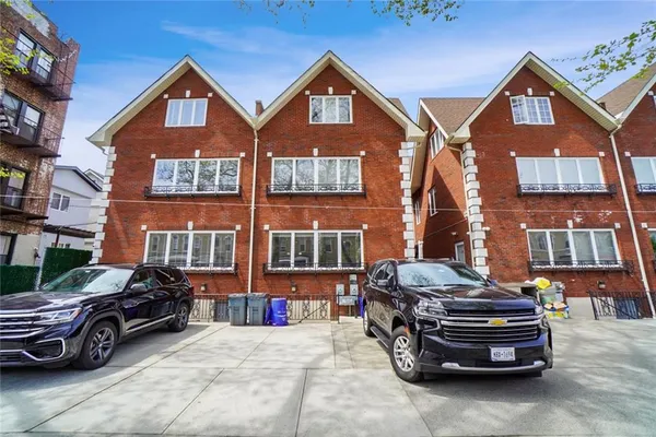 a car parked in front of a brick house