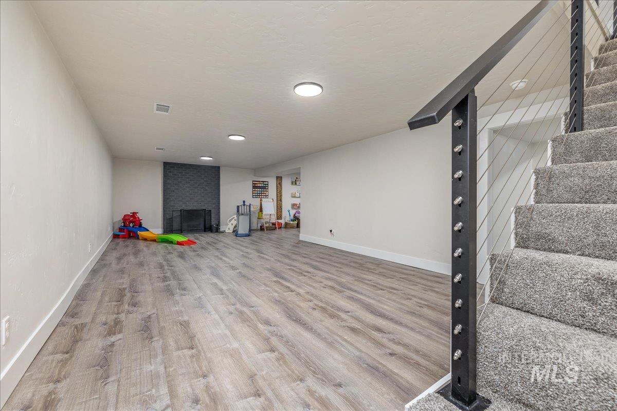 23011 Allendale Road Parma, ID 83660 - Photo 27 of 50 Spacious finished lower level with wood-finish flooring, a contemporary fireplace with dark tile surround, and recessed lighting