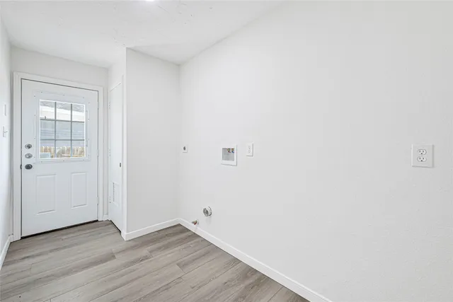 a view of an empty room with wooden floor