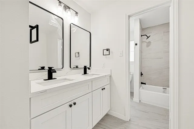 a bathroom with a bathtub shower sink and mirror