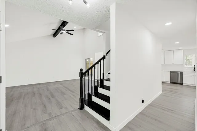 a view of a hallway with stairs to other room