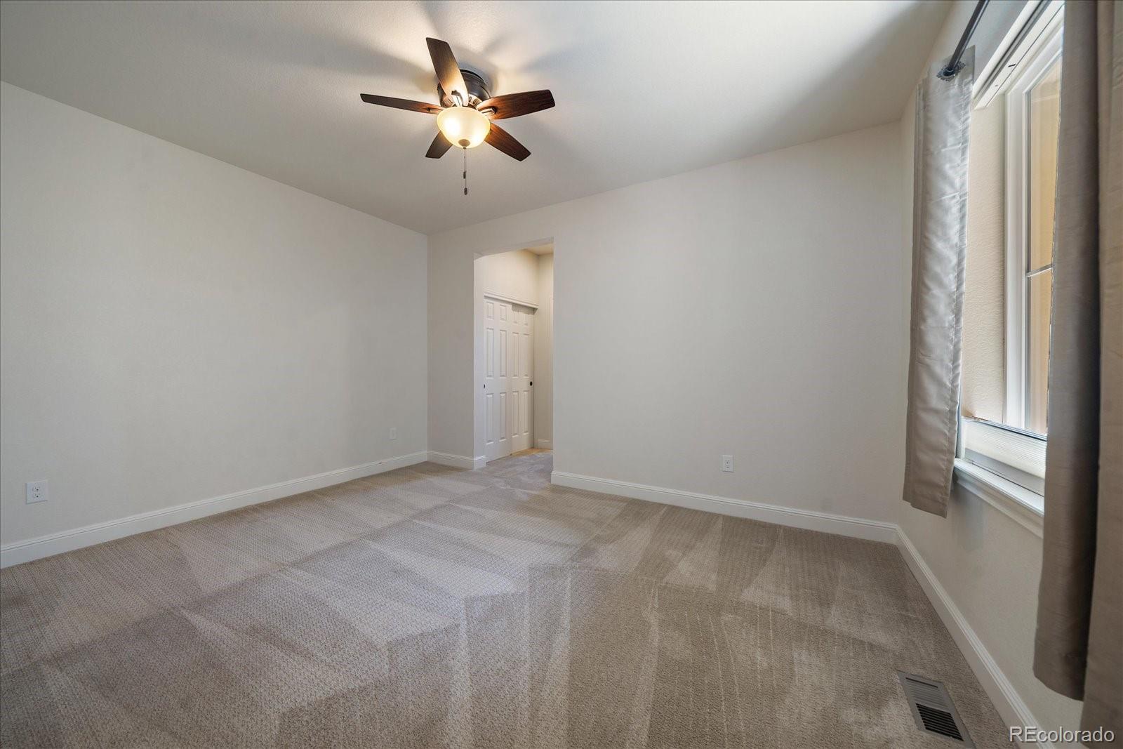 10845 Graphite Street Broomfield, CO 80021 - Photo 14 of 25 an empty room with a window and a fan