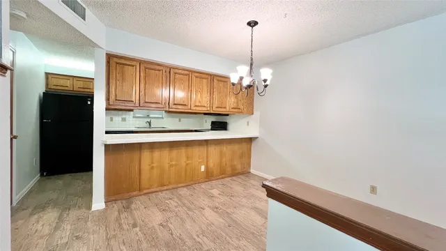 a view of kitchen with granite countertop stove top oven and refrigerator