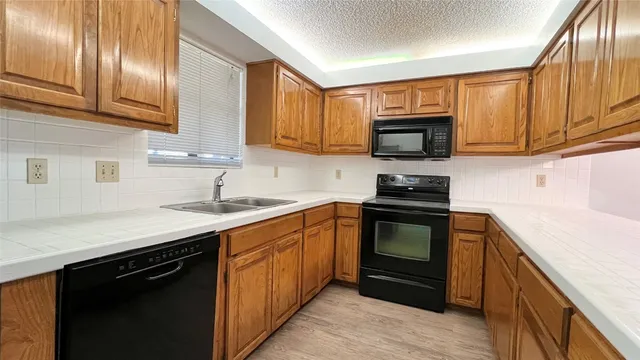 a kitchen with granite countertop wooden cabinets and a stove top oven