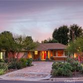 a front view of a house with a yard and lake view