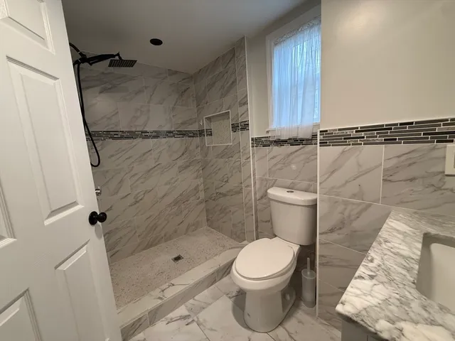 a bathroom with a toilet and a shower