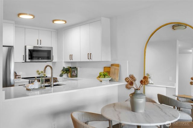 a kitchen with sink a stove and chairs
