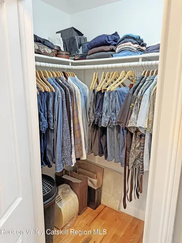 a view of walk in closet with clothes and shoes
