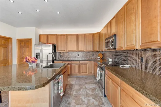 a kitchen with stainless steel appliances granite countertop a sink stove and cabinets
