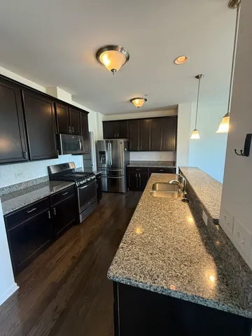 a kitchen with stainless steel appliances granite countertop a sink stove and refrigerator