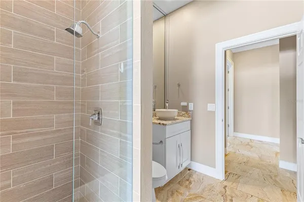 a bathroom with a shower a sink and a mirror