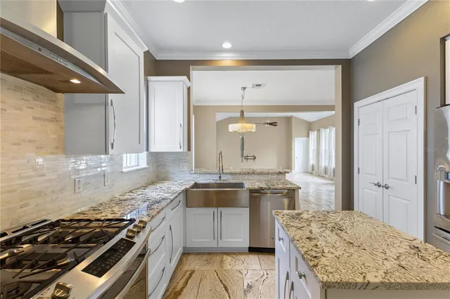 a kitchen with stainless steel appliances granite countertop a refrigerator and a stove top oven