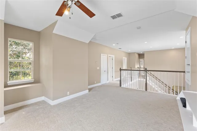 a view of an empty room with closet and a window