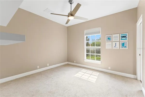an empty room with windows and fan