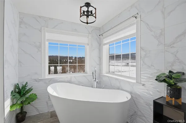 a bathroom with a tub sink and mirror
