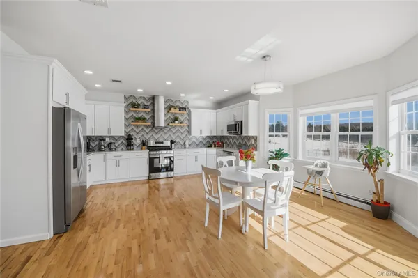a living room with stainless steel appliances kitchen island granite countertop furniture wooden floor and a kitchen view